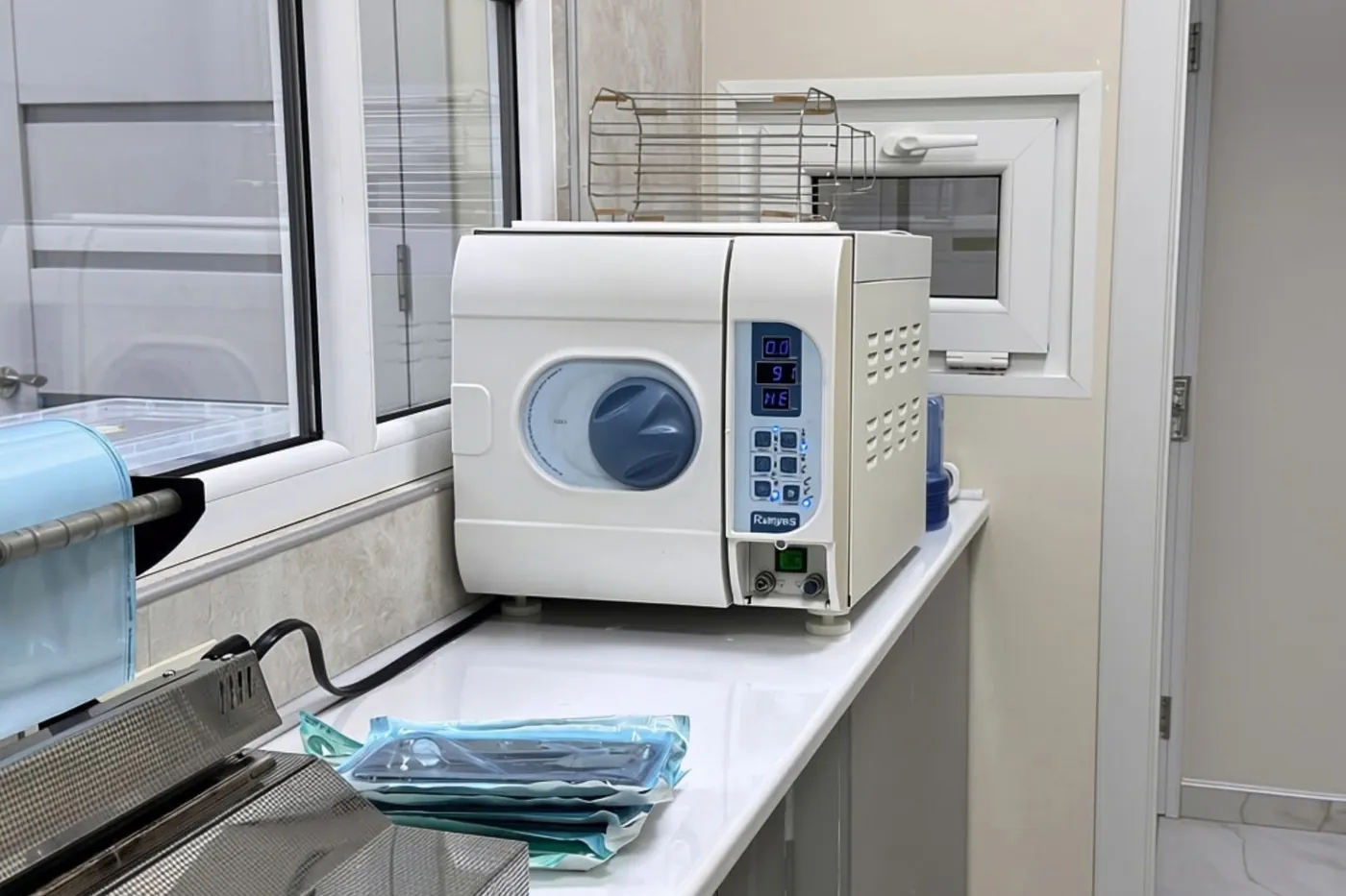 The autoclave and sealed instrument pouches in the clinic's sterilisation area